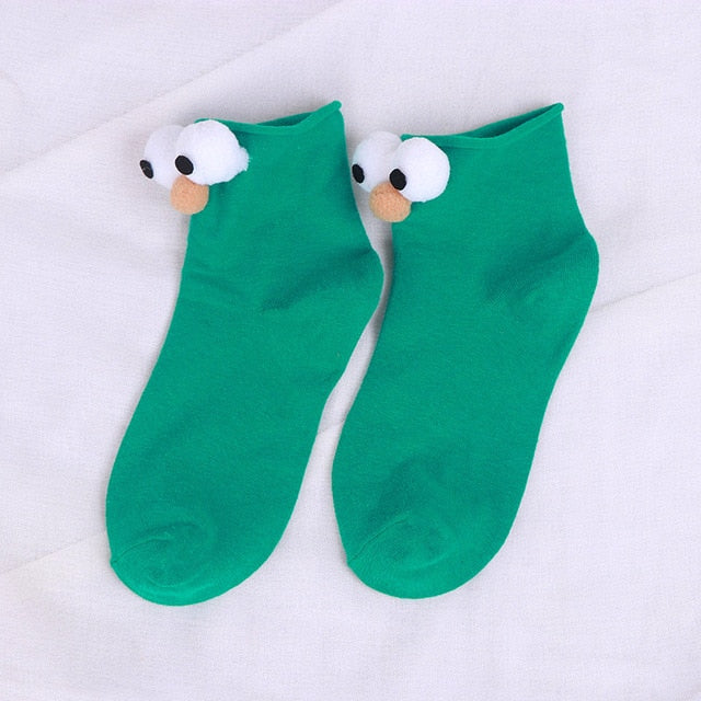 Womens green cartoon socks with eyes and nose.